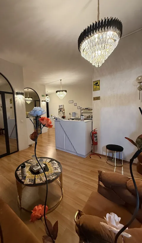 Salon girişi: kristal avize, açık renkli resepsiyon bankosu ve kadife koltuklar