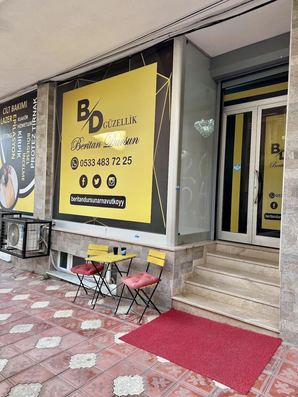 Dış cephe: sarı BD Güzellik tabelası, yanında hizmet listesi panosu ve giriş kapısı